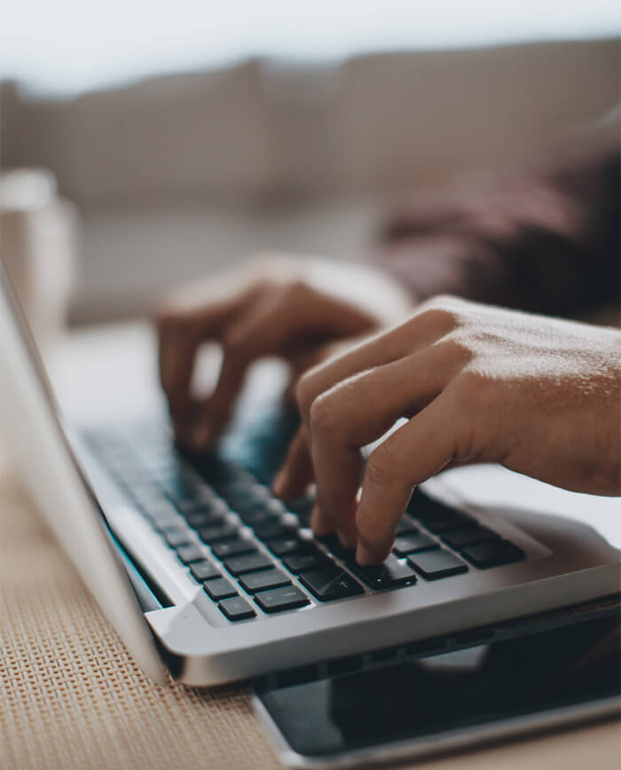 Hands typing on laptop computer