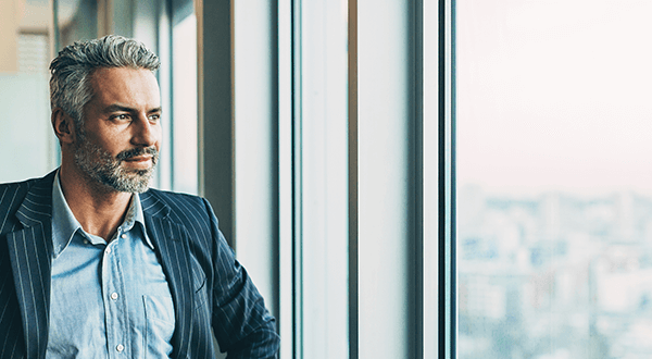 A business professional in an office looking out the window stock photo